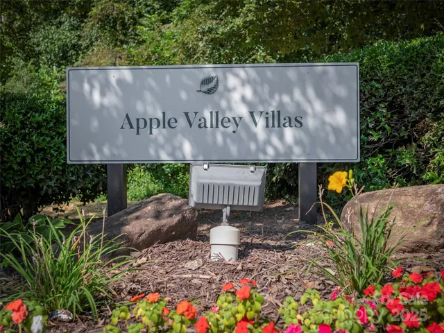 a backyard of a house with table and chairs under an umbrella