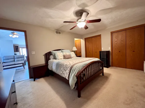 a bedroom with a large bed and ceiling fan