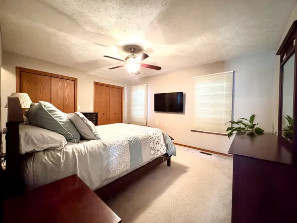 a bedroom with a large bed and a flat screen tv