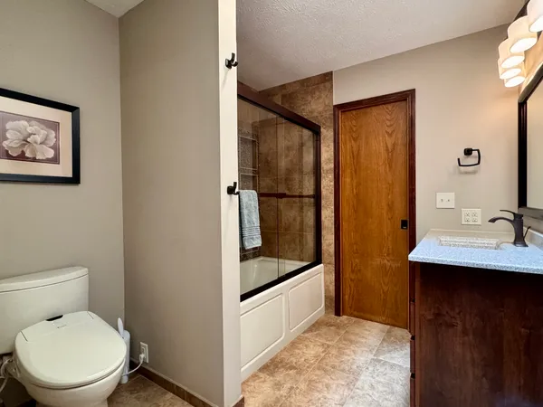 a bathroom with a toilet a sink and mirror