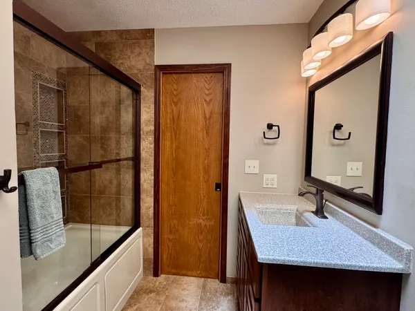 a bathroom with a sink a mirror and shower