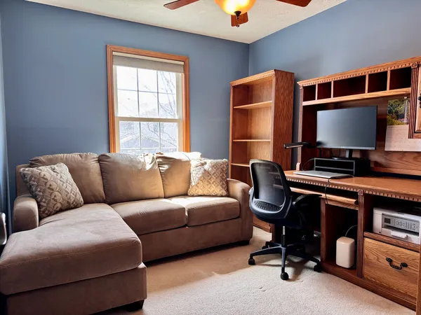 a living room with furniture a flat screen tv and a window