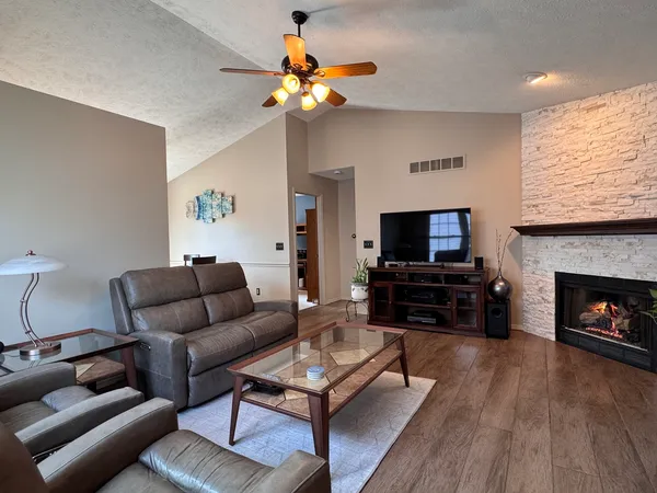 a living room with furniture a flat screen tv and a fireplace