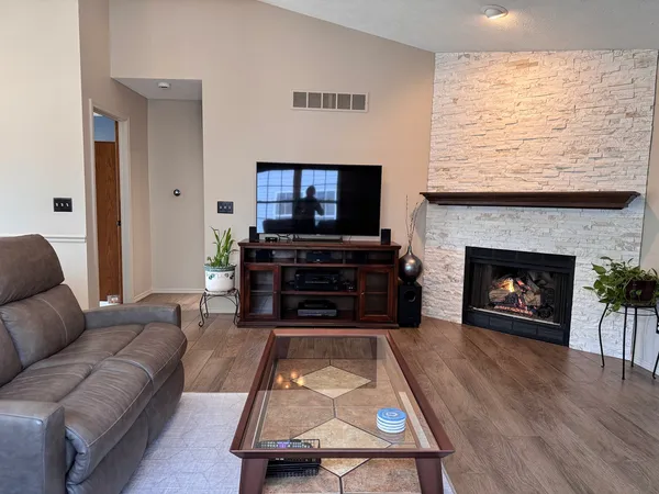a living room with furniture a flat screen tv and a fireplace