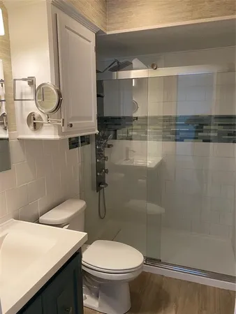 a bathroom with a sink a toilet and shower