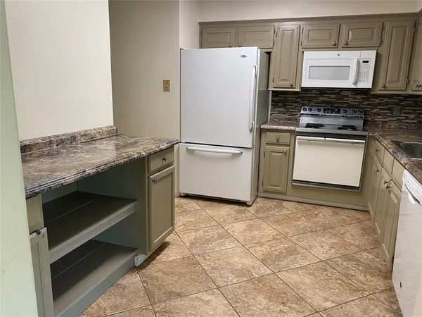 a kitchen with a stove top oven and cabinets