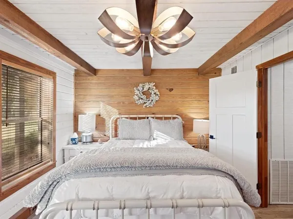 a bedroom with a large bed and a chandelier