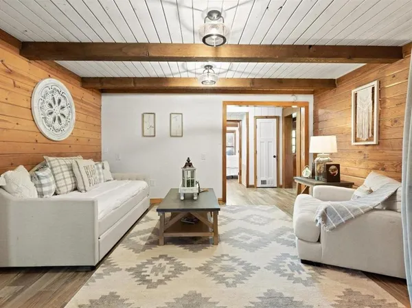 a living room with furniture a clock on wall and a large window