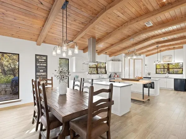 a dining room with wooden floor table and chairs