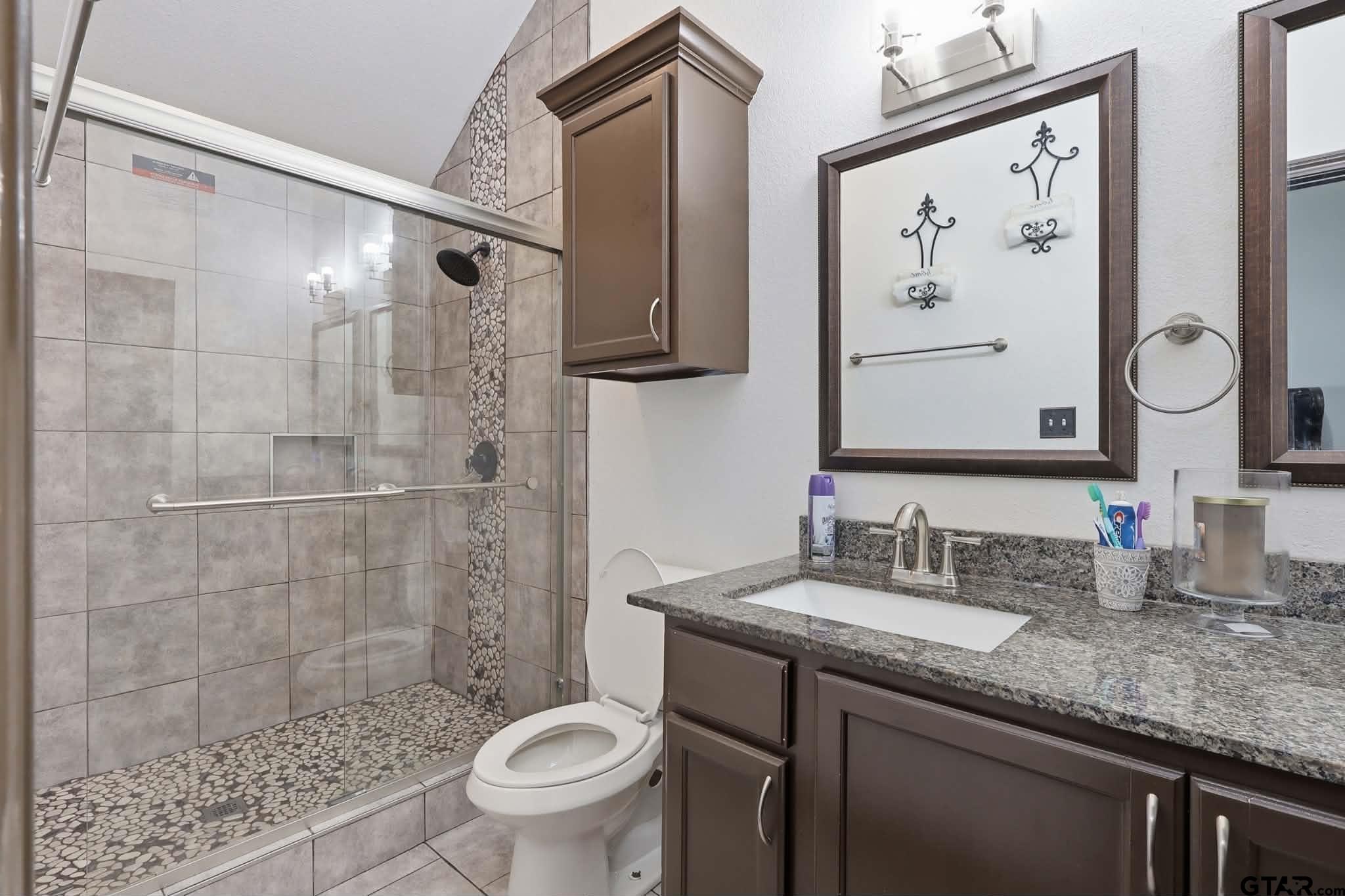 1933 Highway 11 Pittsburg, TX 75686 - Photo 15 of 34 a bathroom with a granite countertop sink toilet and shower