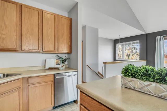 a kitchen with stainless steel appliances granite countertop a sink a stove and a wooden cabinets