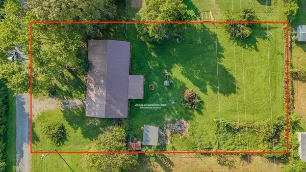 an aerial view of a house with a yard basket ball court and outdoor seating