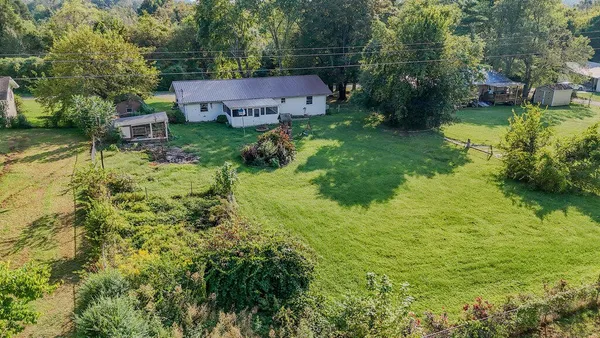a aerial view of a house with a yard and large trees