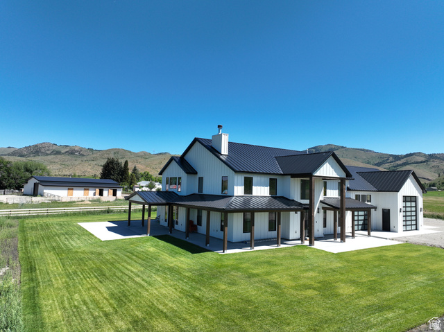 100 Whit Lane Georgetown, ID 83239 - Photo 67 of 76 Back of property featuring a mountain view, a yard, covered porch, a chimney, and a standing seam roof