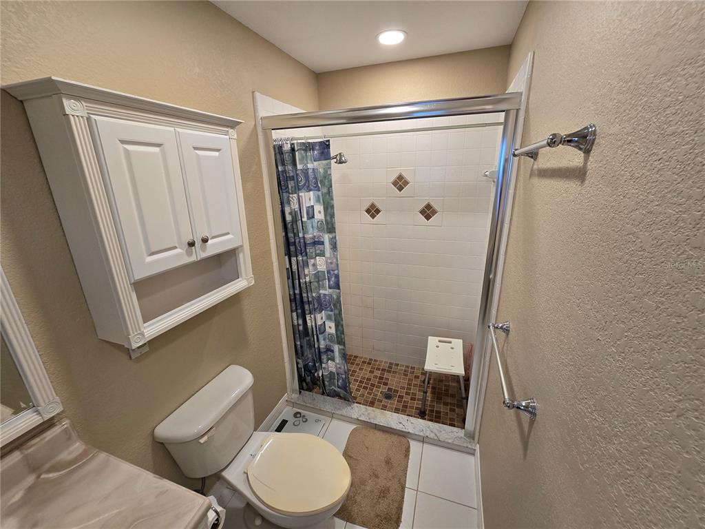 22200 Oneida Avenue Port Charlotte, FL 33952 - Photo 13 of 26 a bathroom with a shower a toilet and a sink