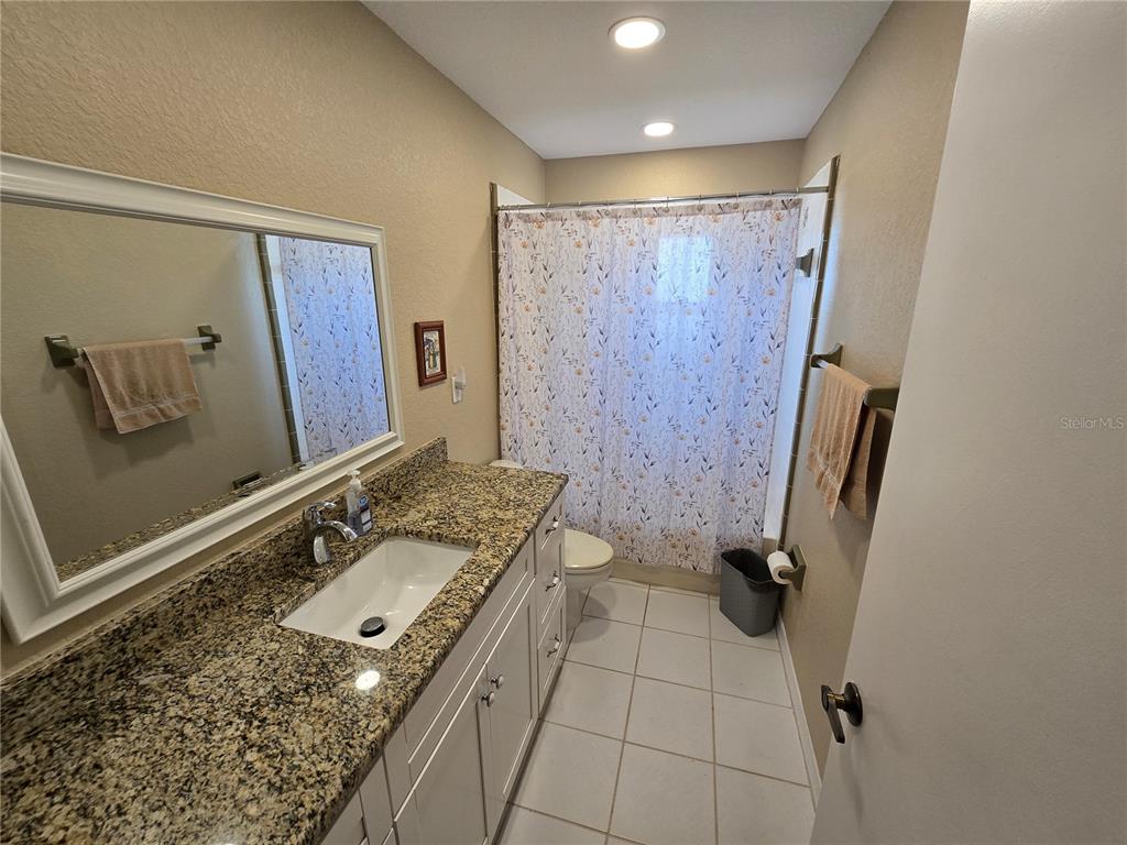 22200 Oneida Avenue Port Charlotte, FL 33952 - Photo 18 of 26 a bathroom with a granite countertop sink and a mirror