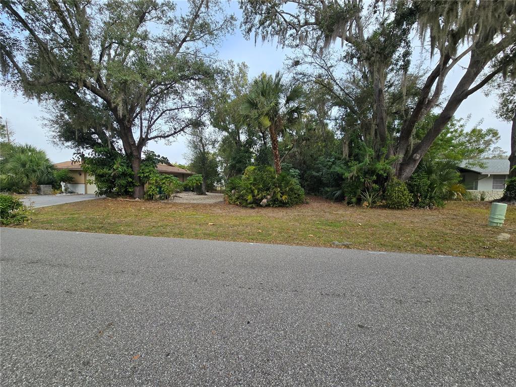 22200 Oneida Avenue Port Charlotte, FL 33952 - Photo 2 of 26 a view of a house with a yard and palm trees