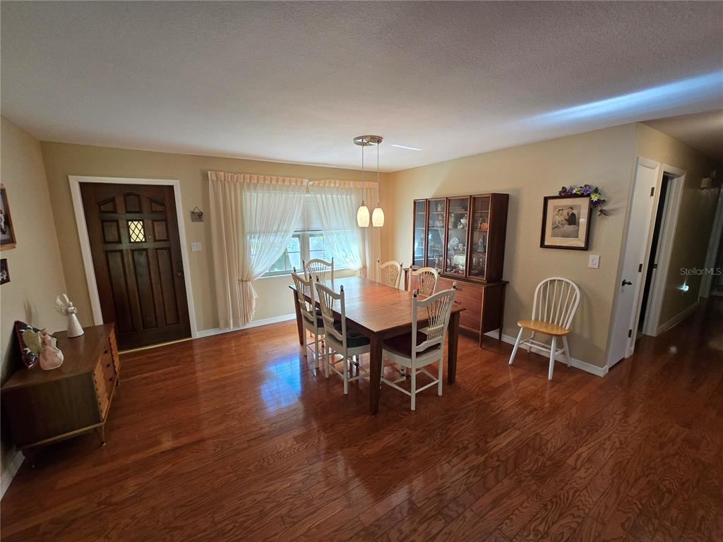 22200 Oneida Avenue Port Charlotte, FL 33952 - Photo 5 of 26 a view of a dining room with furniture and wooden floor