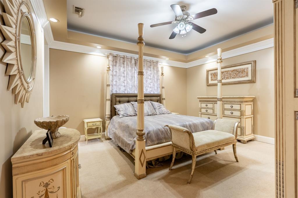 1450 Meandering Way Rockwall, TX 75087 - Photo 17 of 32 a bedroom with a bed and a chandelier