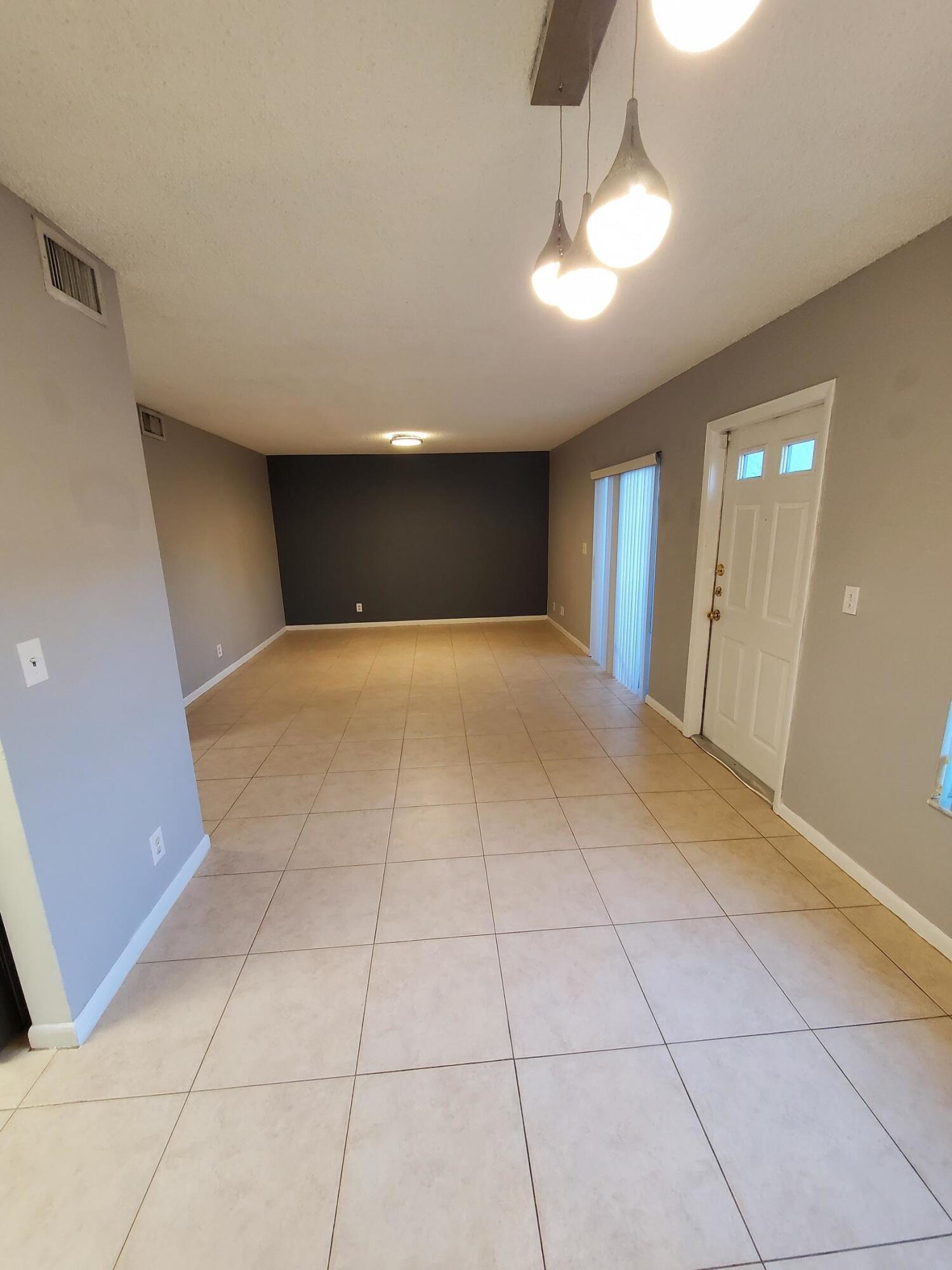 2445 Southwest 22nd Avenue, Unit 1020 Delray Beach, FL 33445 - Photo 16 of 37 a view of an empty room with a chandelier fan