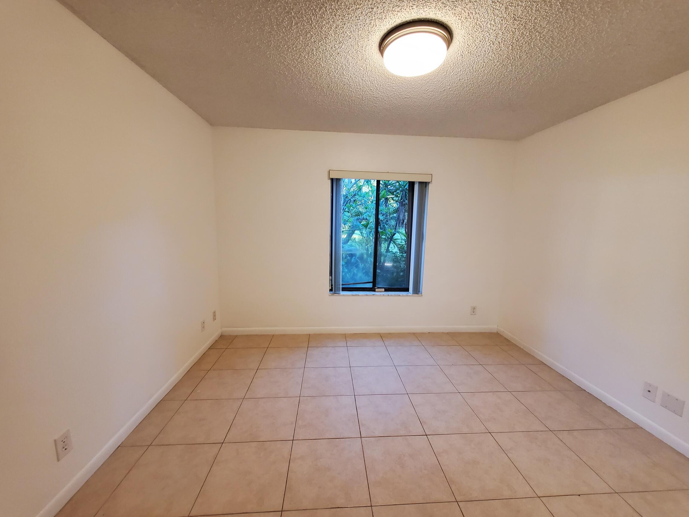 2445 Southwest 22nd Avenue, Unit 1020 Delray Beach, FL 33445 - Photo 25 of 37 an empty room with windows and closet