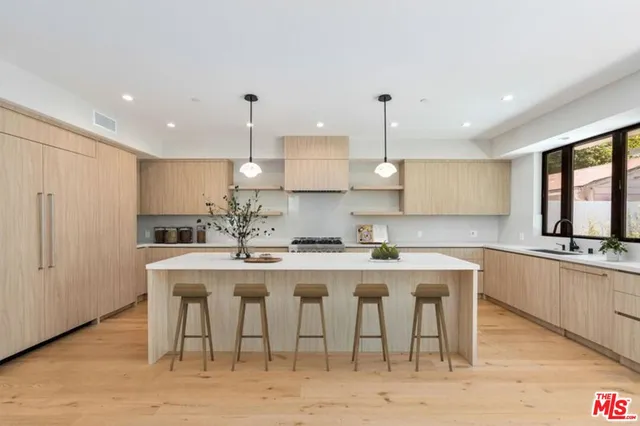 a kitchen with stainless steel appliances granite countertop a sink a stove a refrigerator and island