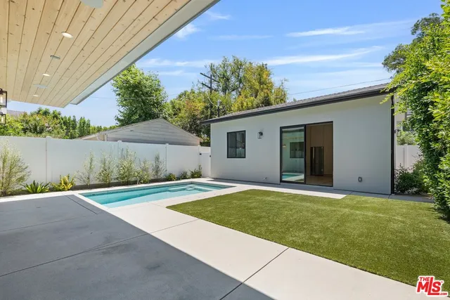 a view of a backyard with potted plants and a tree