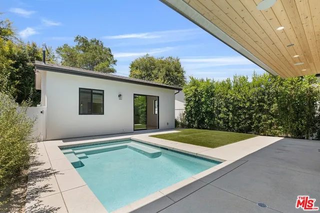 a view of a backyard with plants and a patio