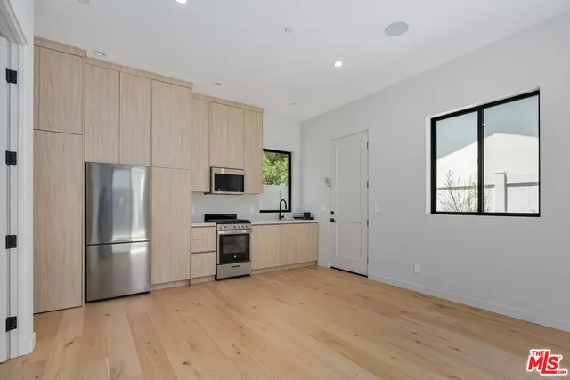 a kitchen with a refrigerator and a stove top oven