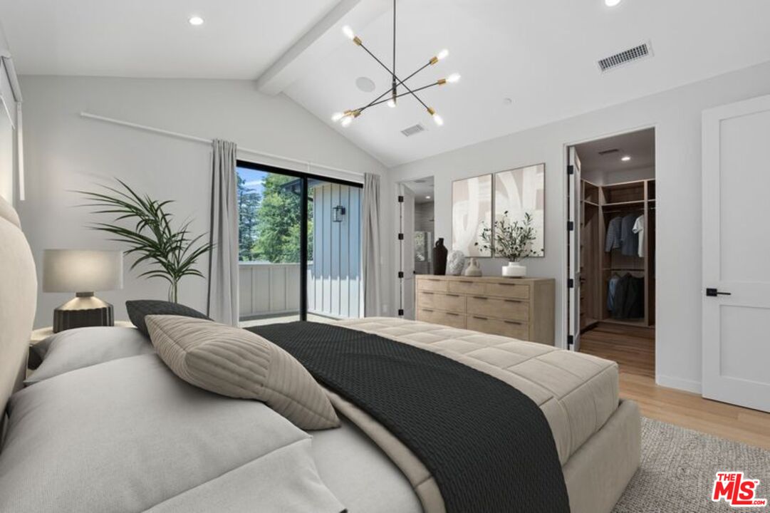 4647 Morse Avenue Sherman Oaks, CA 91423 - Photo 33 of 47 a bedroom with a large bed and a chandelier