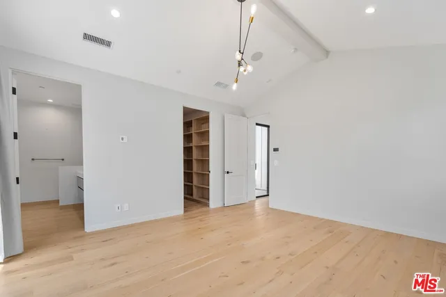an empty room with closet and windows