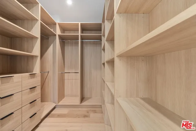 a view of walk in closet with empty racks