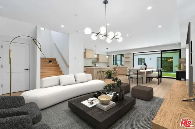 a living room with furniture potted plant and a chandelier