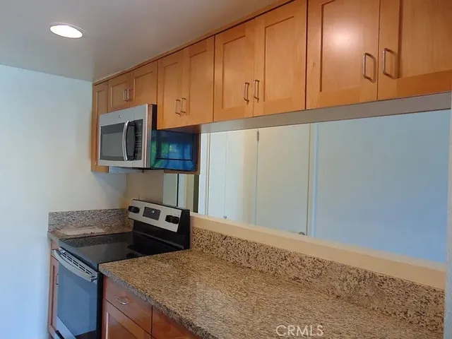 a kitchen with granite countertop cabinets stainless steel appliances and a sink