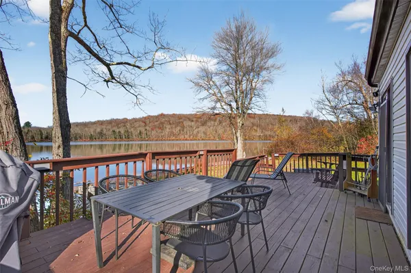 a view of a house with wooden deck and furniture