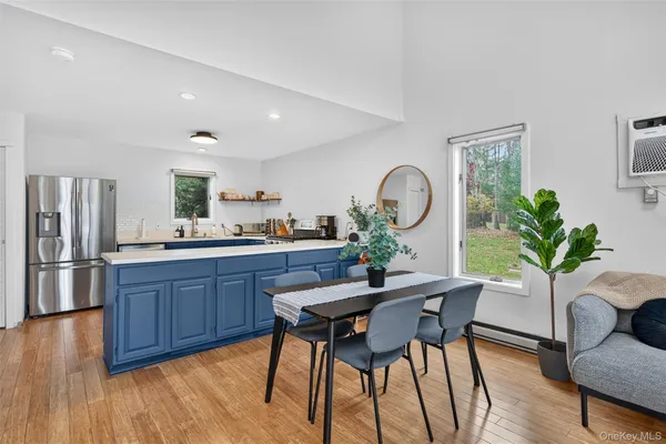 a kitchen with a table chairs refrigerator and wooden floor