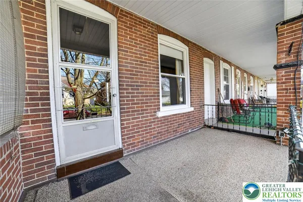 a front view of a house with yard porch and sitting area