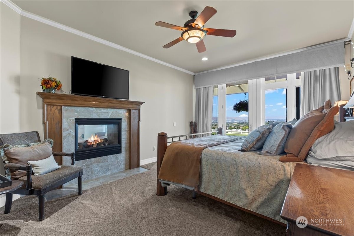 201 Wendt Road Yakima, WA 98901 - Photo 12 of 32 a bedroom with a bed a fireplace and a chandelier