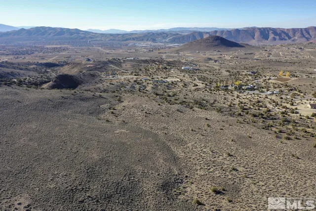 a view of a dry yard with mountains in the background