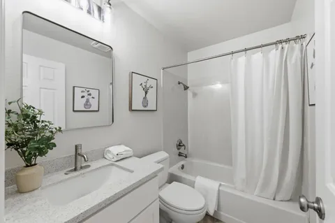a bathroom with a granite countertop sink toilet and shower