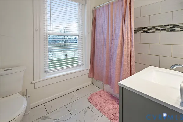 a bathroom with a sink a toilet a mirror and shower