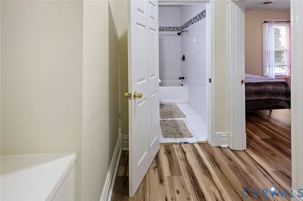 a bedroom with two beds and wooden floor