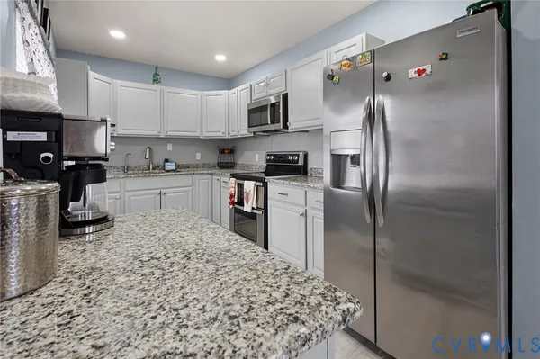 a kitchen with stainless steel appliances granite countertop a stove a sink dishwasher and a refrigerator