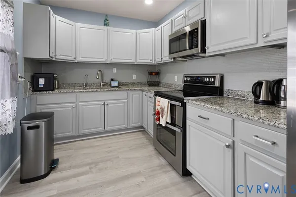 a kitchen with white cabinets and stainless steel appliances