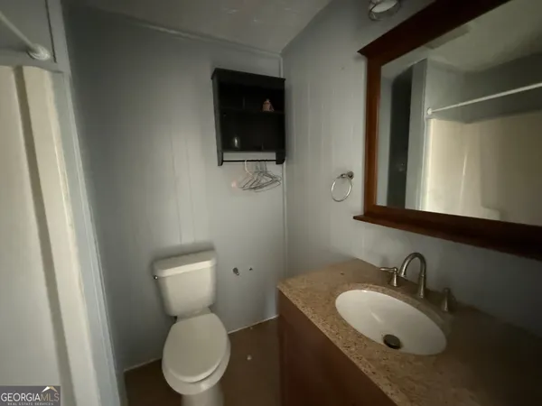 a white house that has tree in front of it