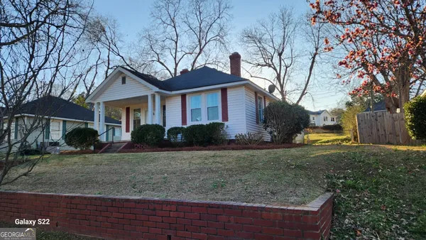 a view of a yard in front of a house with large trees