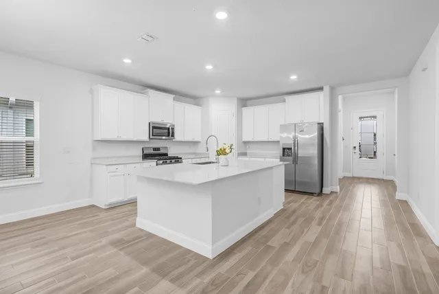 a kitchen with stainless steel appliances a refrigerator and a stove top oven