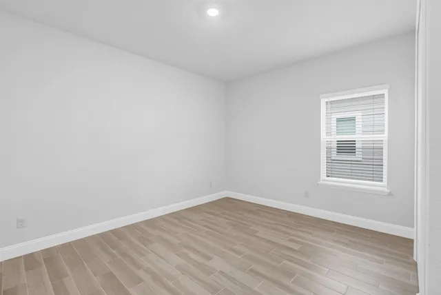 a view of a hallway with wooden floor and windows