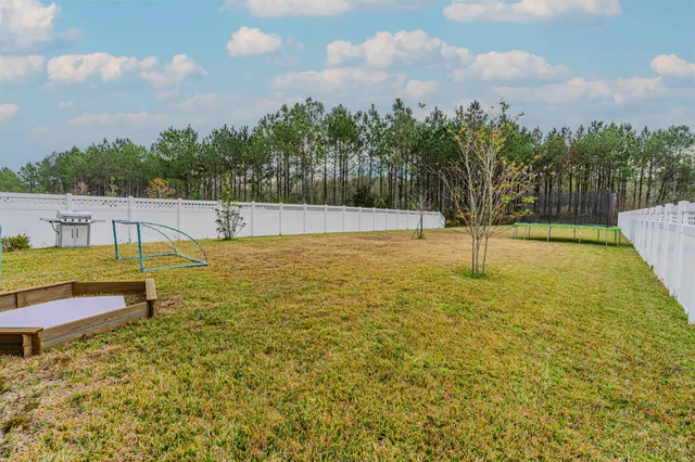 a front view of a house with garden and trees