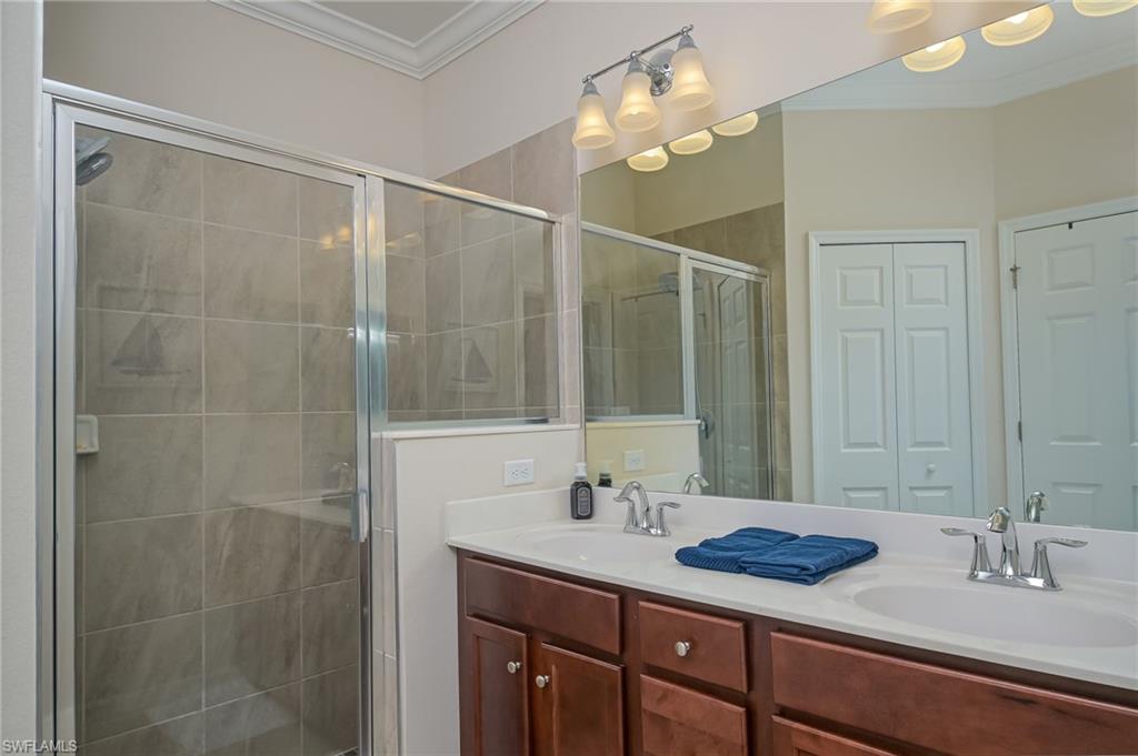 1803 Alameda Drive Naples, FL 34120 - Photo 12 of 30 a bathroom with a granite countertop sink a mirror and a shower